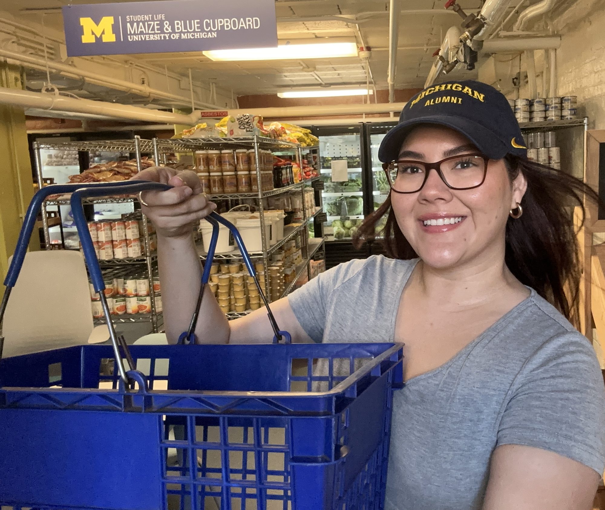 Ruth holding a shopping basket at the University of Michigan Maize & Blue Cupboard, shot for a healthy college recipes series.