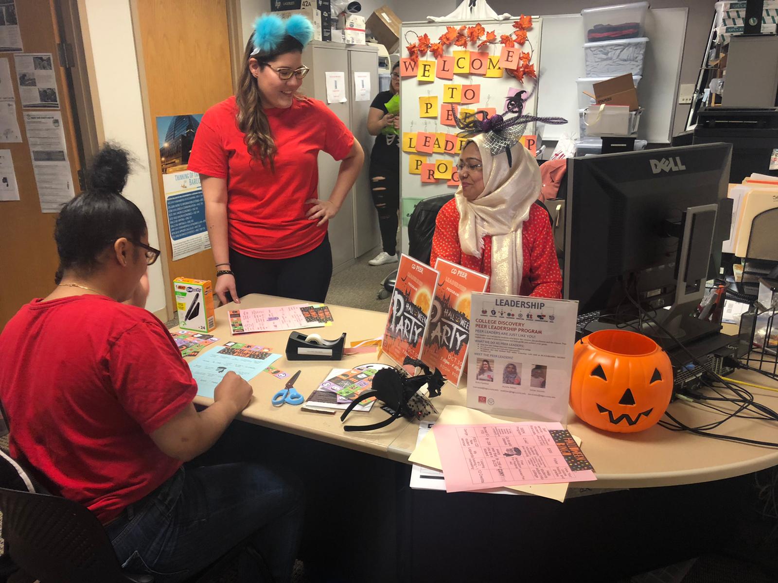 College Discovery peer leaders preparing Halloween party materials in the program office.